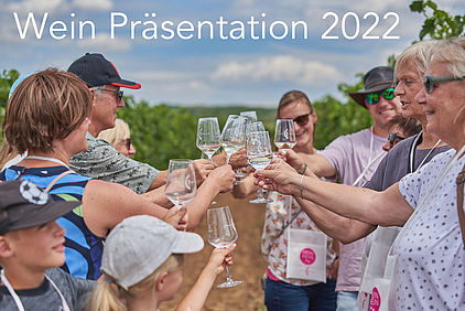 Besucher der Wein Präsentation 2022 stoßen in Weinbergen an